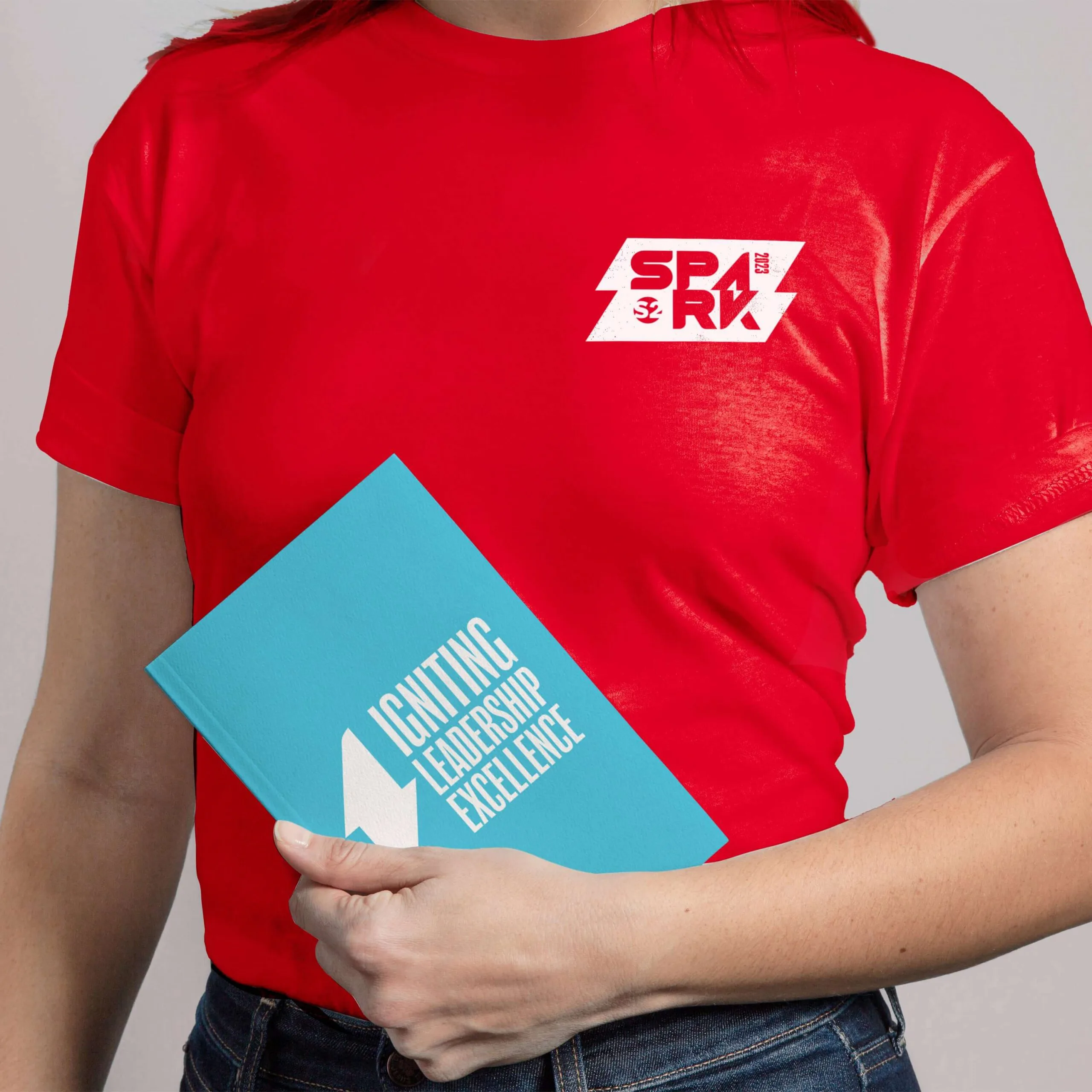 S2 Spark Co branded red t-shirt and Igniting Leadership Excellence booklet